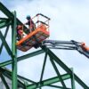 Nacelle élévatrice avec opérateurs sur une charpente métallique